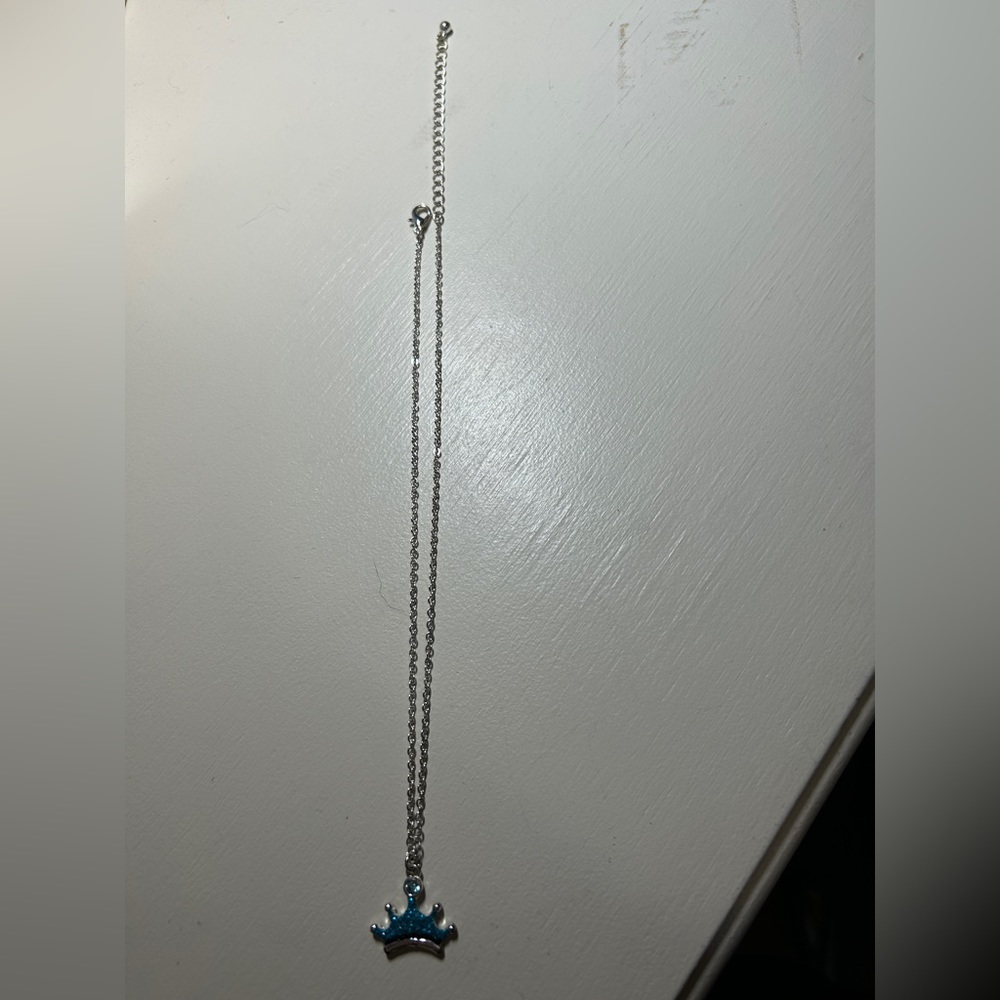 Girls 14” silver necklace w/3” extender. Has a blue crown pendant. Gently used.